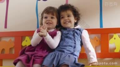 幼儿园两个可爱的小女孩在教室里玩耍、拥抱